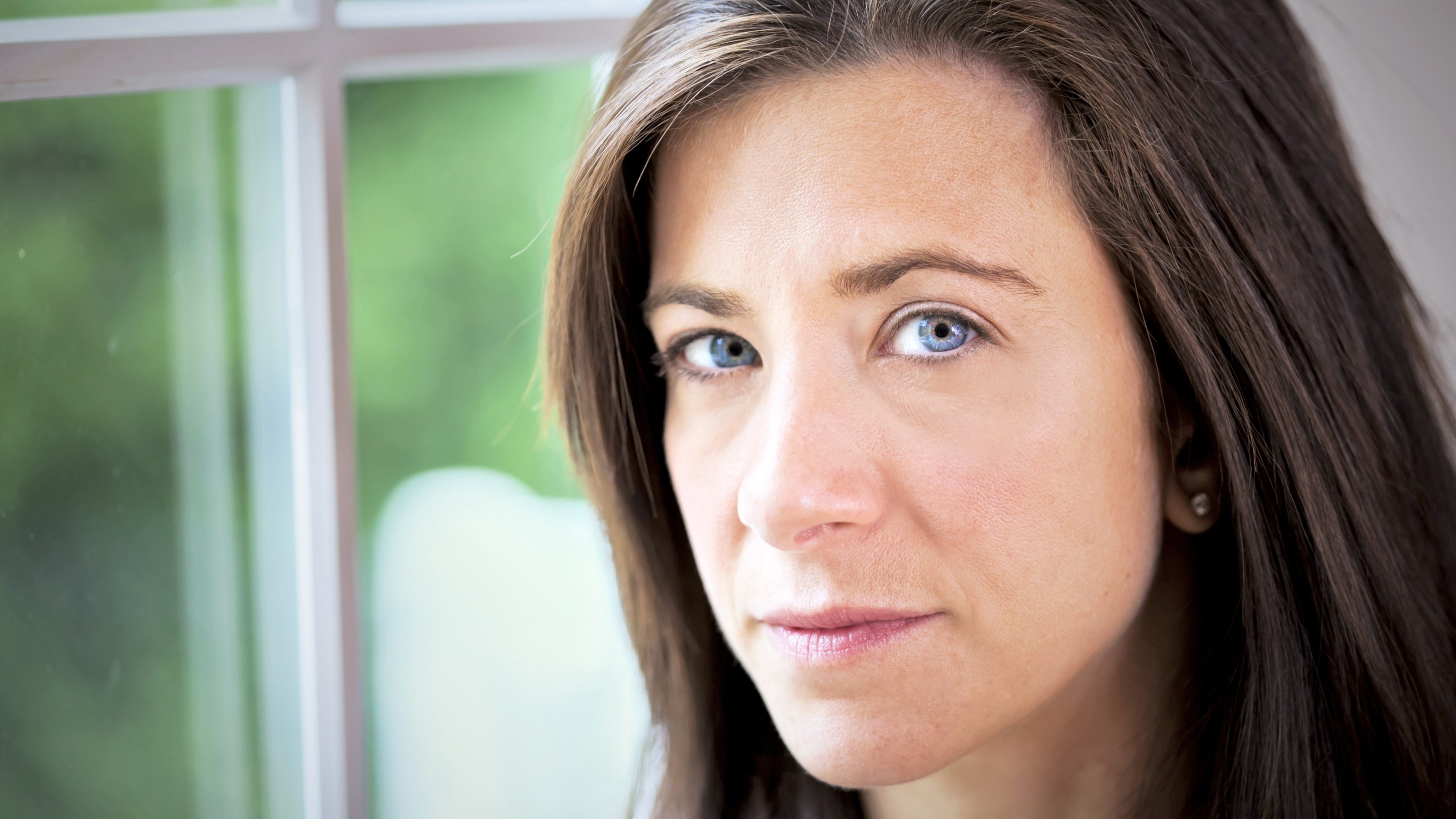 Businesswoman with a serious expression standing by window