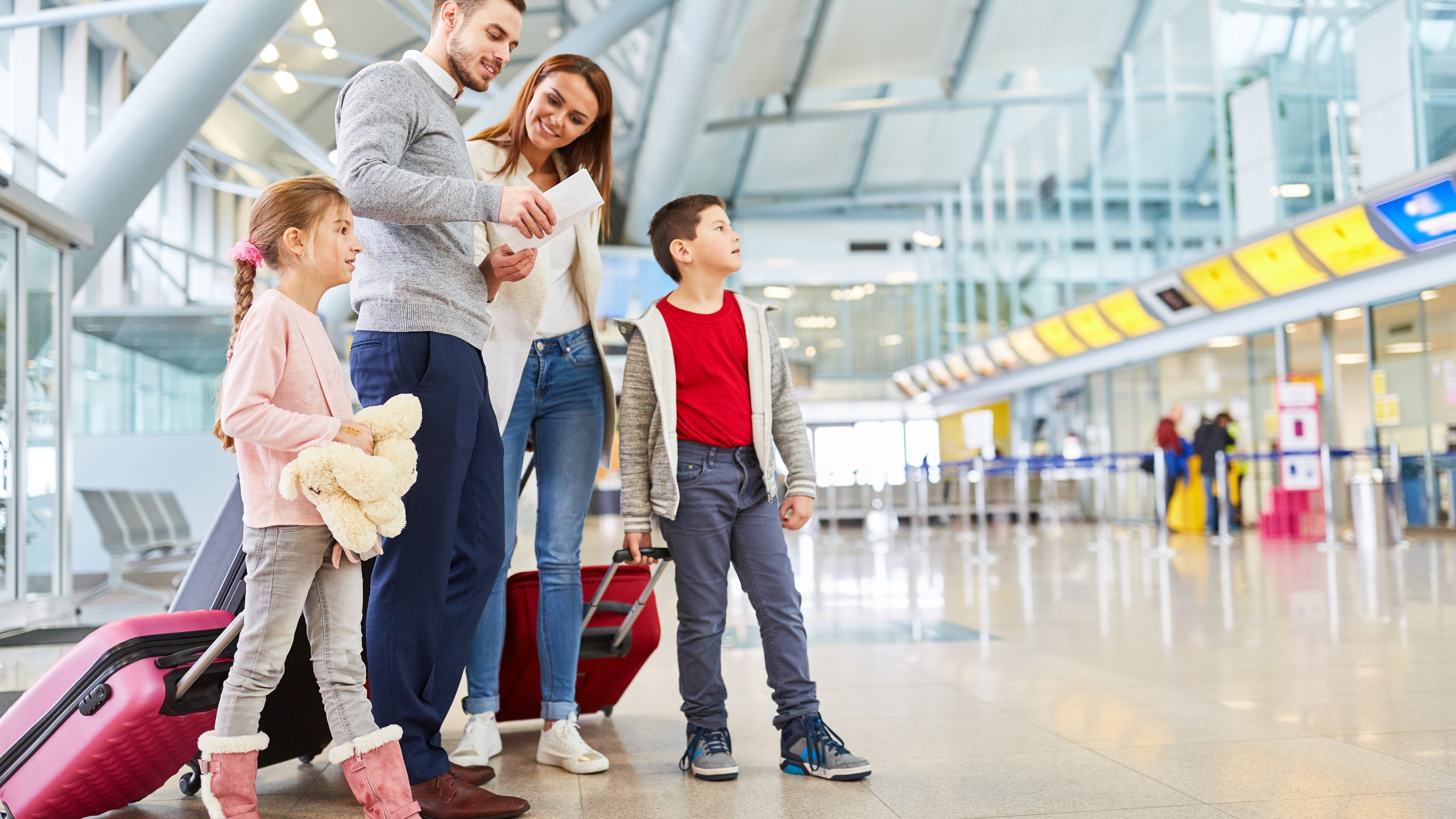 Family and children with luggage in airport terminal fly together on vacation