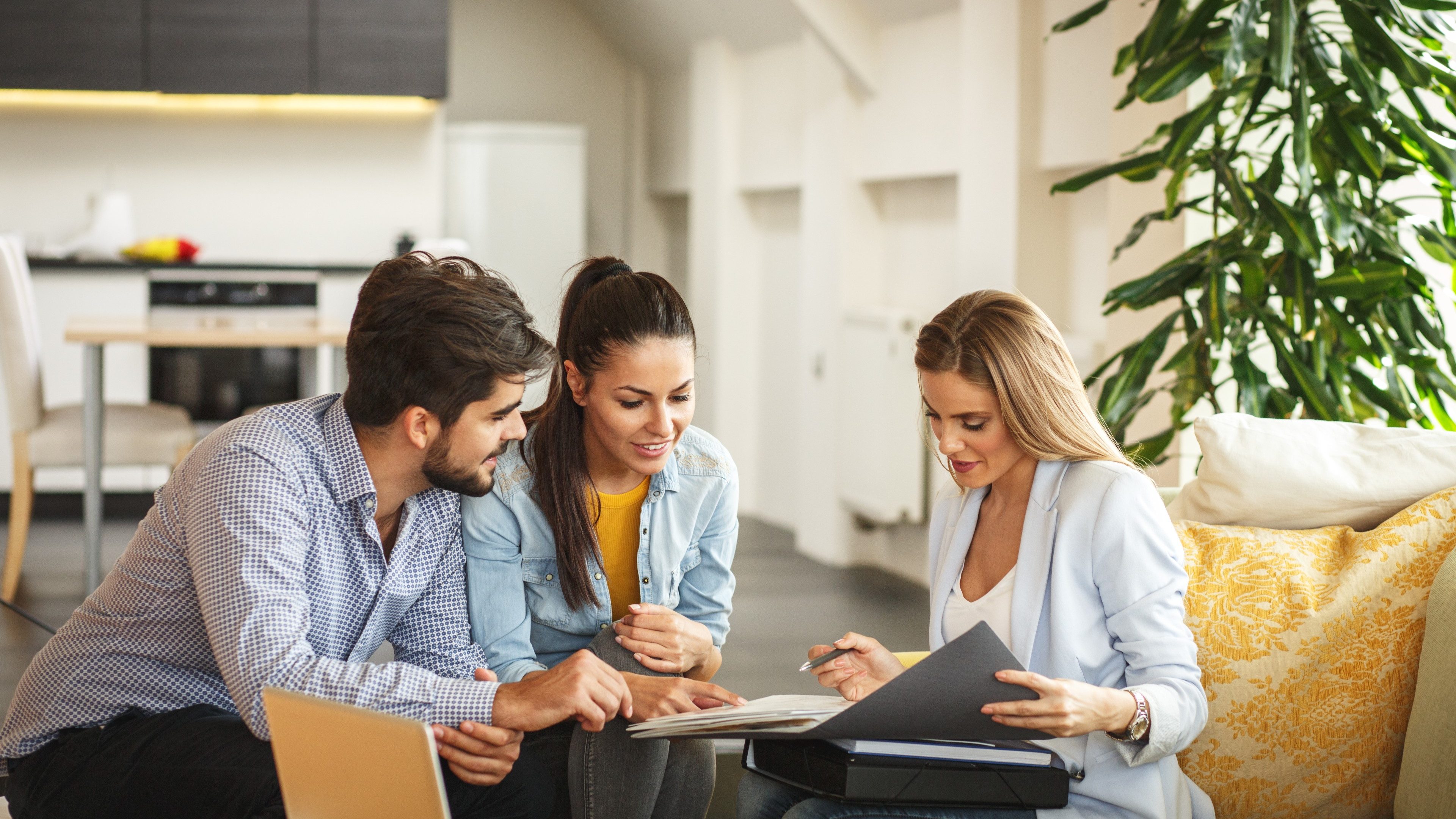 Female Real Estate agent offer home ownership and life insurance to young couple.