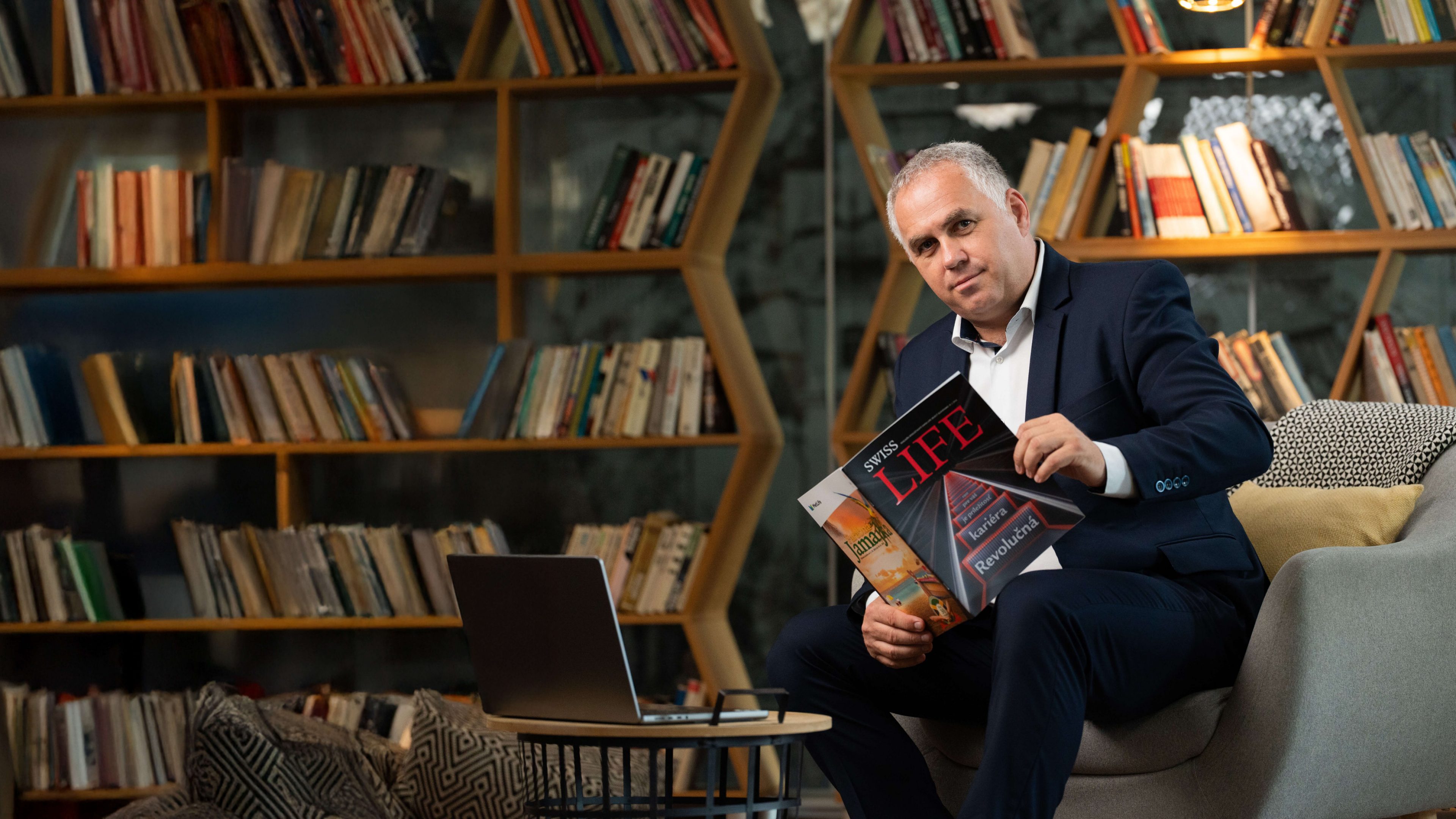 Richard Nalevako, Regionálny riaditeľ Swiss Life Select Slovensko si v knižnici číta Swiss LIFE magazín.
